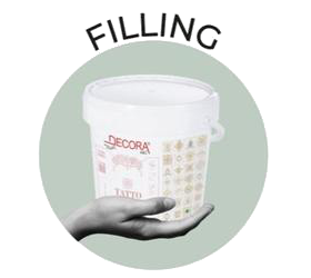 Hand holding a bucket of Decora lime-based filling material, representing expert craftsmanship by specialty contractors.